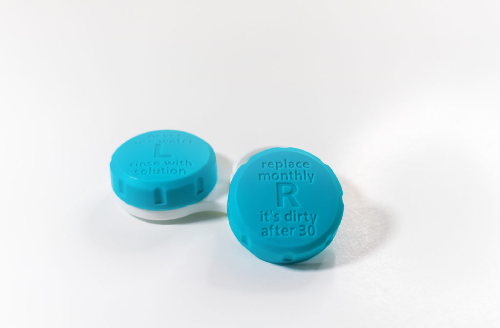 A blue-colored container of contact lenses featuring a label on the lid instructing to replace the lenses after 30 days.