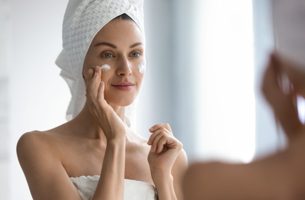 A person applying face cream for healthy, glowing skin.