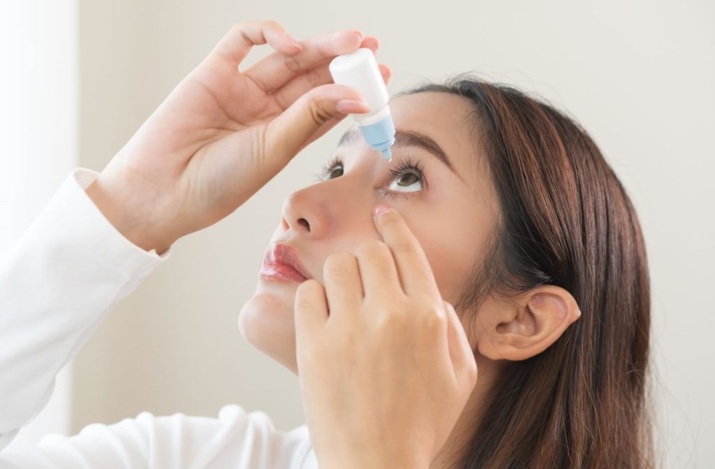 A woman using eye drops to relieve her dry eyes from MGD