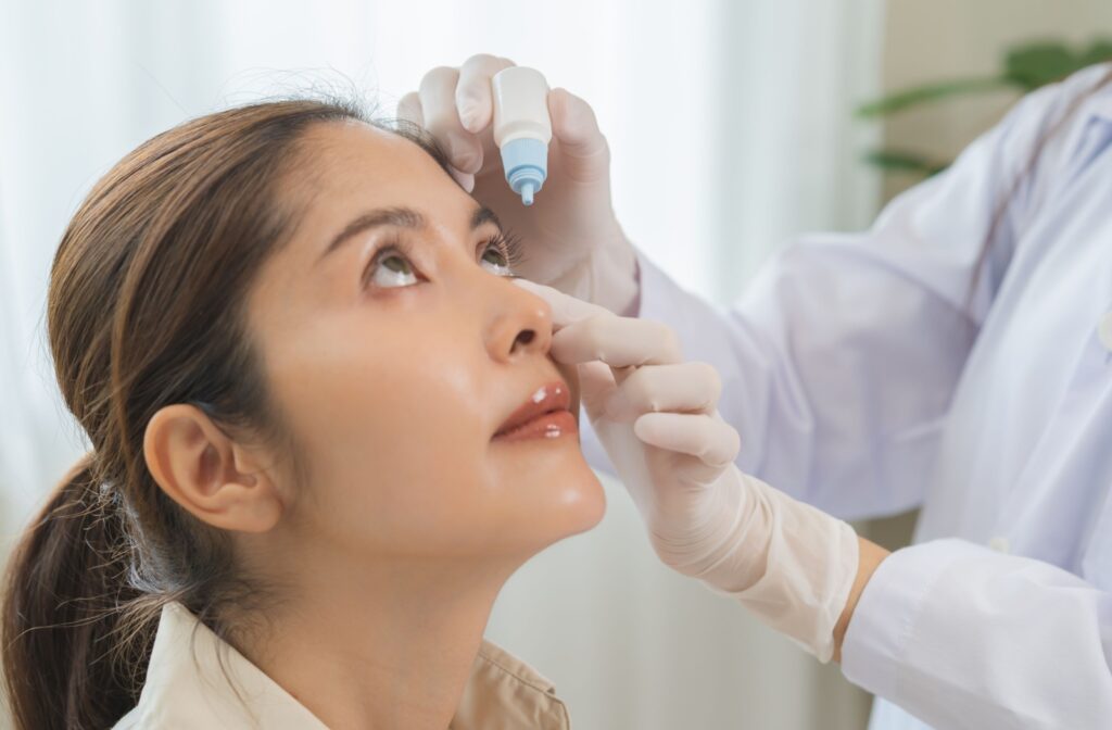 A patient receiving eye drops for dry eye treatment at an optometrist's office.