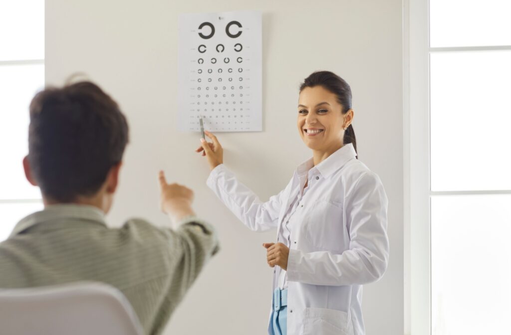 A smiling optometrist performs a vision test to check for myopia in a young patient.