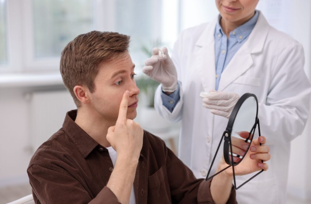 Patient learning how to insert a contact lens with help from an optometrist.
