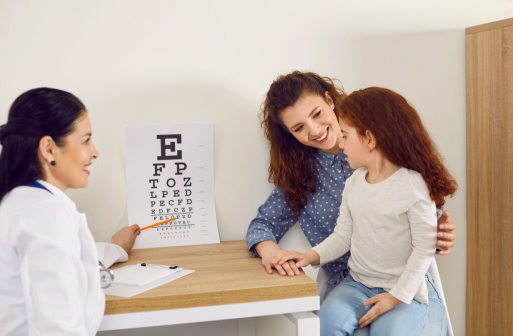 Mom with her daughter at the optometrist's office looking at an eye chart.